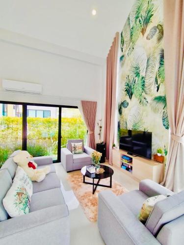 a living room with two couches and a tv at Relax Pool Villa Khaoyai - รีแล็กซ์พูลวิลล่าเขาใหญ่ in Ban Bung Toei