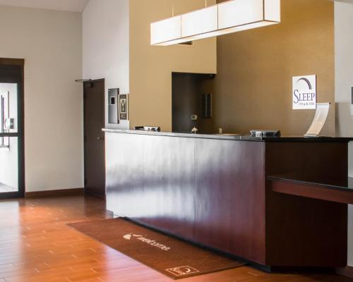 a kitchen with a refrigerator and a counter top at Sleep Inn & Suites Columbus in Columbus
