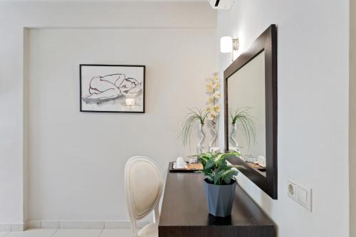 a mirror in a room with a table and a chair at Aerinon Guesthouse in Nafplio