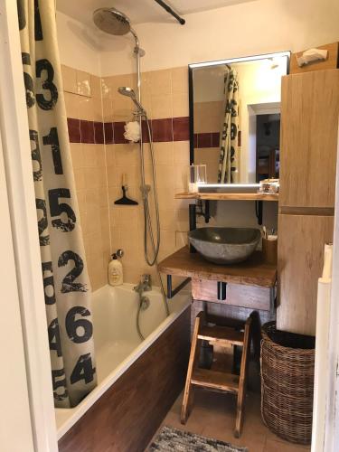 une salle de bain avec une baignoire, un lavabo et un miroir dans l'établissement Appartement vue montagne, à Les Estaris