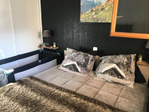 une chambre avec un lit avec deux oreillers dessus dans l'établissement Appartement vue montagne, à Les Estaris