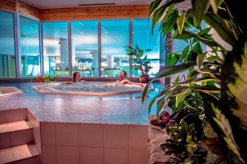 2 personnes dans un bain à remous dans un bâtiment dans l'établissement Appartement vue montagne, à Les Estaris