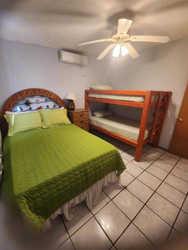 a bedroom with a green bed and bunk beds at Casa mexicana in San Felipe