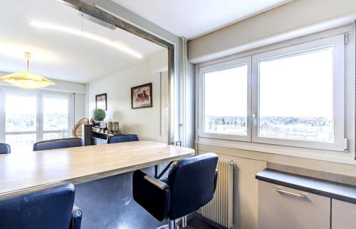 une salle de réunion avec une grande table et des chaises en bois dans l'établissement Le Belvédère spacieux lumineux avec 2 chambres, à Montbéliard