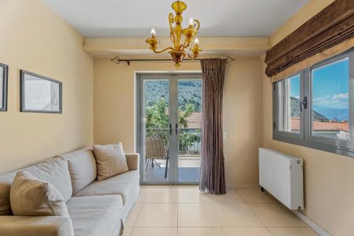 a living room with a couch and a large window at Aerinon Guesthouse in Nafplio