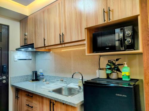 a small kitchen with a sink and a microwave at The Solace Place- Near Nuvali Sta Rosa Laguna in Bayabasan