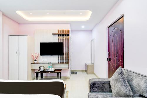 a living room with a couch and a tv at Super Collection O SF Road Siliguri Formerly Jyoti Hotel in Siliguri