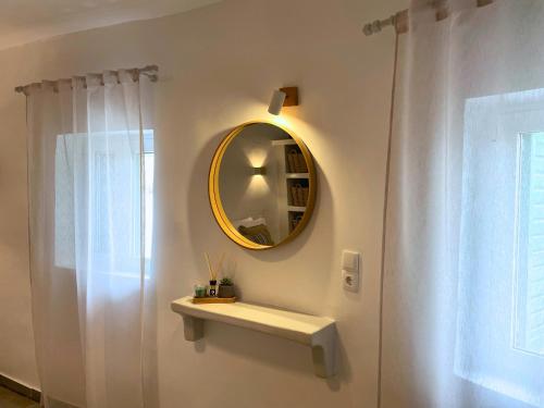 a bathroom with a mirror and a white shower curtain at Dryopis Studio in Kithnos