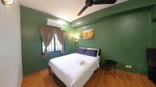 a bedroom with green walls and a bed with white sheets at 4-10 pax, Open concept BBQ at Private Seaview in Port Dickson
