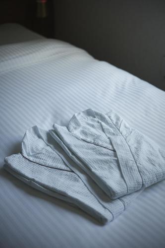 a white towel sitting on top of a bed at THE HERO VILLA 米原ビーチリゾートishigaki in Ishigaki Island