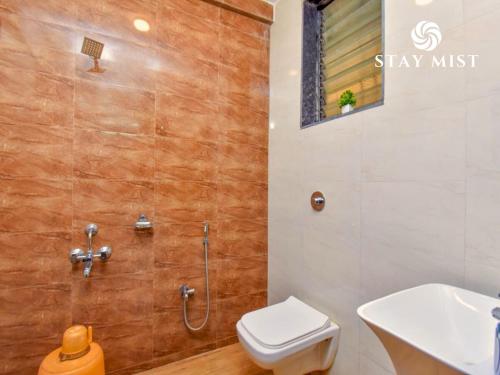 a bathroom with a shower and a toilet and a sink at Staymist - Casa Palais in Lonavala