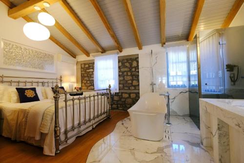 a bedroom with a bed and a tub and a sink at Limnos Experience in Mirina