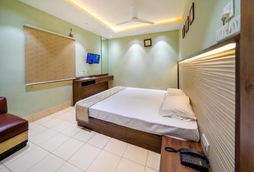a bedroom with a bed and a tv in it at Hotel Dolphin Puri in Puri