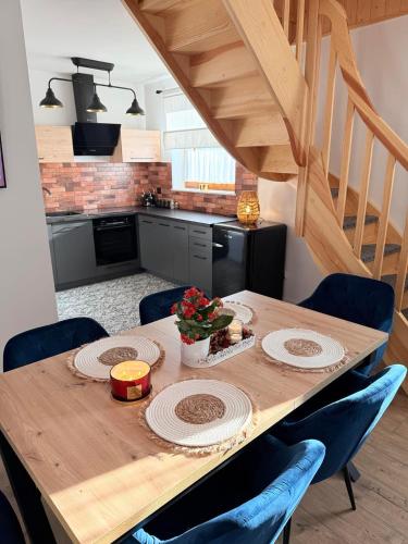 a kitchen with a wooden table with blue chairs at Siedlisko Złota Góra domki całoroczne na Kaszubach in Brodnica