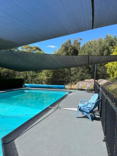 a patio with a swimming pool with a shade over it at Panorama Retreat & Resort in Kalorama