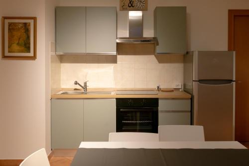 a kitchen with white cabinets and a stainless steel refrigerator at Casa Jack in San Giorgio di Piano