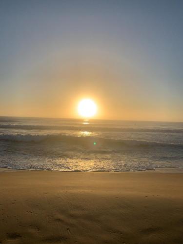 a sunset on the beach with the ocean at Lucky's Coastal Retreat, 2 bedroom apartment and parking in Cronulla