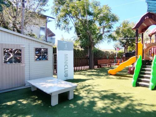 a playground with a bench and a slide at Villaggio Camping Duca Amedeo in Martinsicuro
