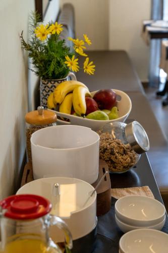 a counter with a bowl of fruit and a bowl of bananas at Aerinon Guesthouse in Nafplio