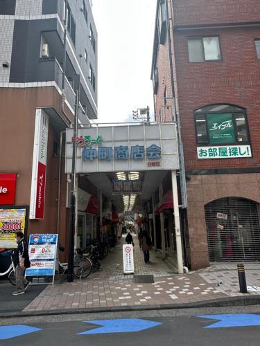 a walkway over a street in a city with buildings at 5mins walk to Kameari Station within 30mins to Ginza, Asakusa, Skytree Direct bus to Haneda Airport & Tokyo Disneyland departing from Kameari Station in Tokyo