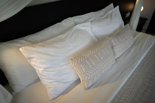 a white bed with two pillows on top of it at Villa Jerami & Spa in Seminyak