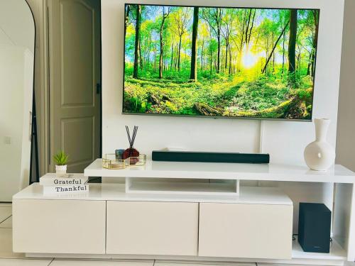 a living room with a tv on a white wall at StayEase 3BR apartment with Pool Spa & Gym in Johannesburg