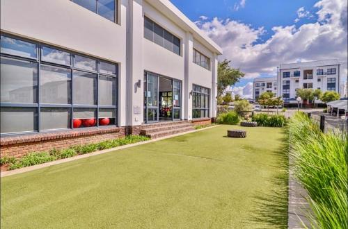 a large white building with a lawn in front of it at StayEase 3BR apartment with Pool Spa & Gym in Johannesburg