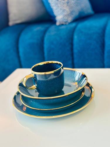 a blue and gold coffee cup and saucer on a table at StayEase 3BR apartment with Pool Spa & Gym in Johannesburg