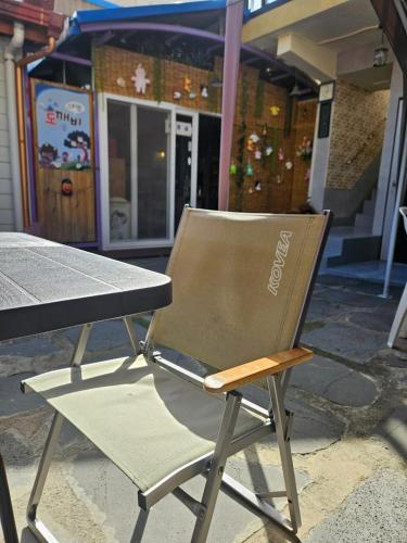 a chair sitting next to a table in front of a building at Doggebi Stay in Gunsan