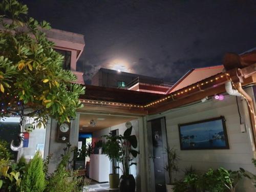 a house with lights on the roof at night at Doggebi Stay in Gunsan
