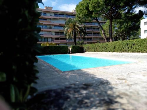 une piscine bleue avec un bâtiment en arrière-plan dans l'établissement Appartement avec vue mer à Antibes, à Antibes