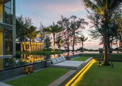 a living area with a couch in front of a building at Baan Mai Khao Beach Residence in Mai Khao Beach