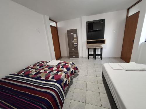 een hotelkamer met een bed en een tv bij Wayki House in Ica