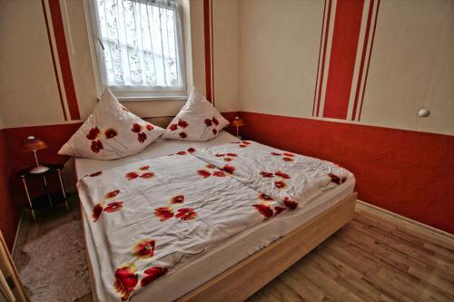 a bedroom with a bed with red flowers on it at Ferienwohnung Thurk in Sassnitz