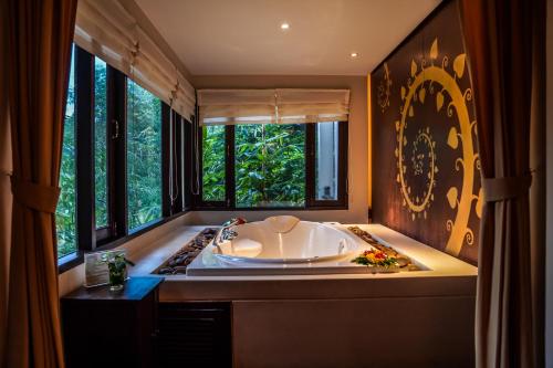 a large bath tub in a bathroom with windows at Suuko Villas in Chalong 