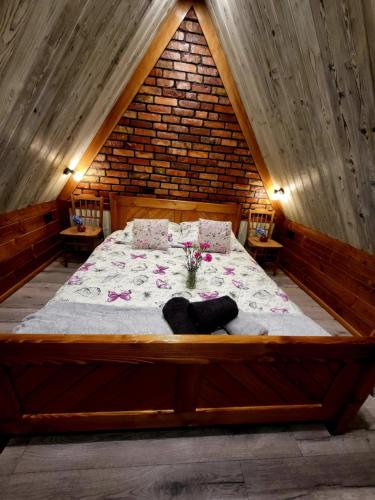a large bed in a room with a brick wall at Apartamenty Gubalowski Las in Nowe Bystre