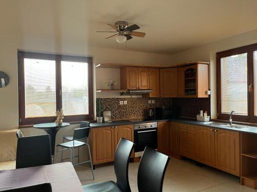 a kitchen with wooden cabinets and a table and chairs at Dom pri kúpalisku Thermalpark na Malotejedskej in Dunajská Streda