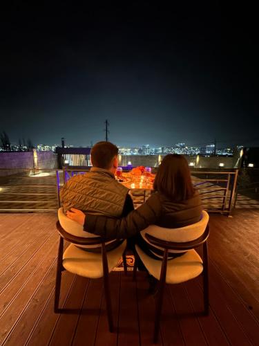 a man and a woman sitting at a table at night at Open House in Orto-Say