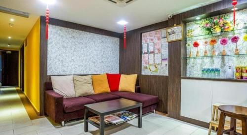 a living room with a purple couch and a table at OYO 90173 Hotel Mekong in Kuala Lumpur