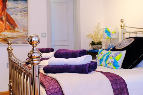 three beds with purple and white blankets and pillows at Limnos Experience in Mirina