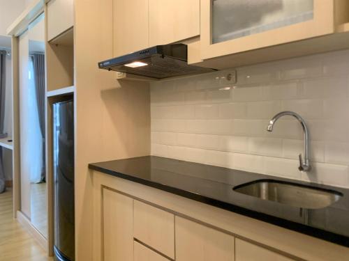 a kitchen with a sink and a stove at Simply Studio at Tokyo Riverside PIK 2 Apartment By Travelio in Rawalembang
