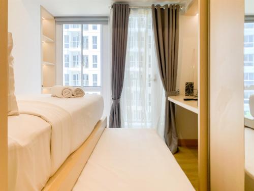 a bedroom with two beds and a window at Simply Studio at Tokyo Riverside PIK 2 Apartment By Travelio in Rawalembang