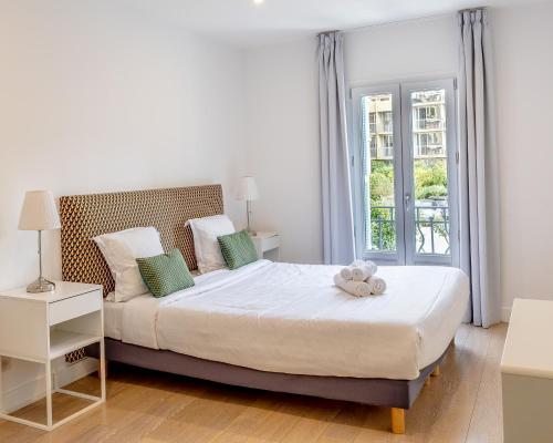 une chambre avec un lit avec un ours en peluche dessus dans l'établissement République Appartements, à Menton