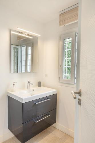 une salle de bain avec un lavabo et un miroir dans l'établissement République Appartements, à Menton