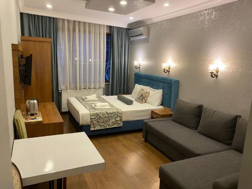 a hotel room with a bed and a couch at Riverland Suites Apart Hotel in Istanbul