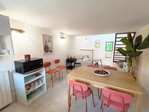 - un salon avec une table et des chaises roses dans l'établissement Rooftop de la Roquette Terrasse Clim, à Arles