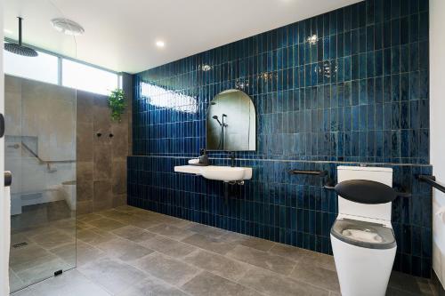a bathroom with a toilet and a sink and a mirror at Castlemaine Gardens Luxury Accessible Villa in Castlemaine