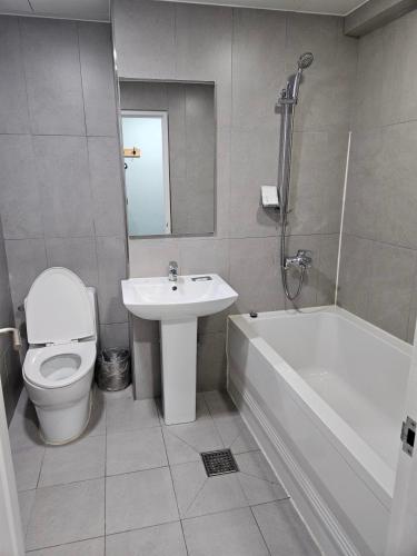 a bathroom with a toilet and a sink and a bath tub at Hotel Junoh in Seoul