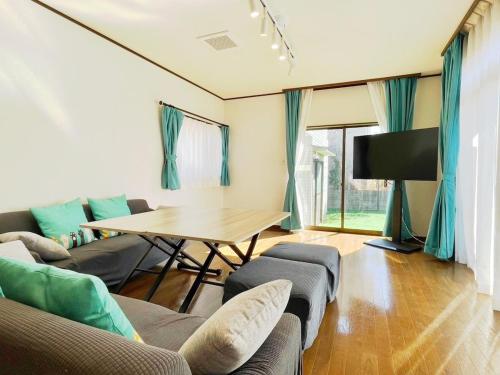 a living room with couches and a table and a tv at Pets OK! Close to the sea! Starlit House with a dog run AC8 in Hasunuma