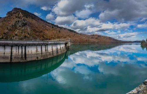a boat sitting in the water next to a mountain at En Kanalion well in Kanália